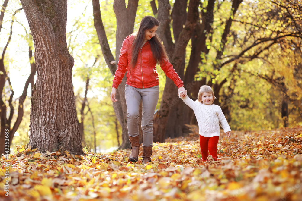 Young family on a walk in the autumn park on a sunny day. Happiness to be together. Young family on a walk in the autumn park on a sunny day. Happiness to be together.