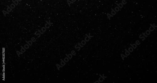 Silver glitter black sand or diamond dust creating abstract shimmering glow formations blinking  metamorphosis. Art background texture glamour