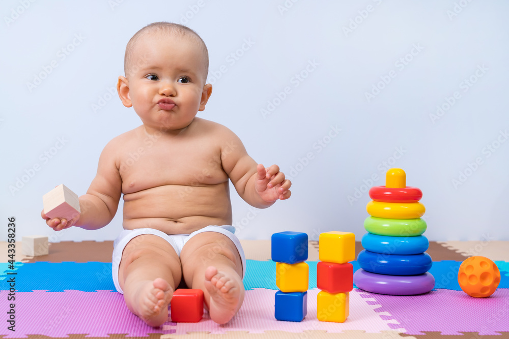 Offended child 8-12 months old, with toys in the playroom. Offended child 8-12 months old, with toys in the playroom.