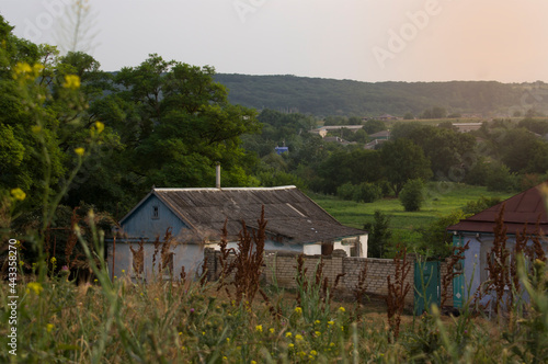 One village house in a field around the grass at sunset in warm colors