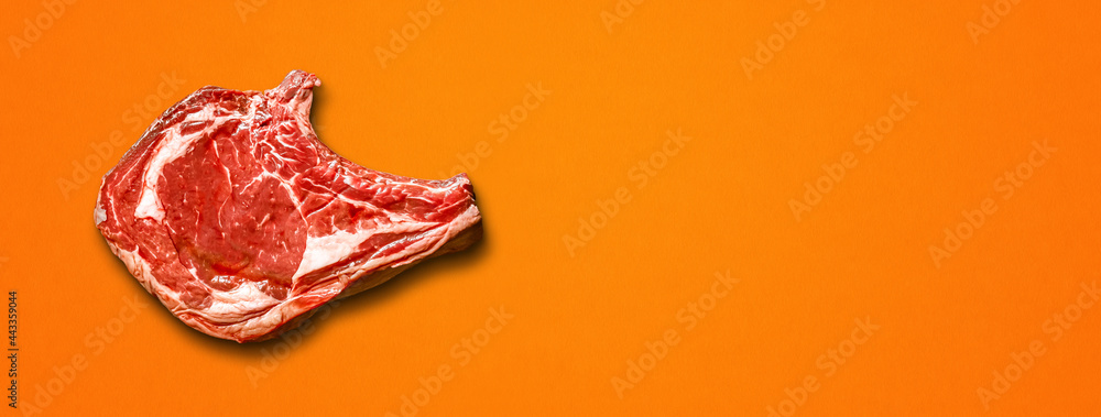 Beef prime rib isolated on orange background. Horizontal banner Beef prime rib isolated on orange background. Horizontal banner