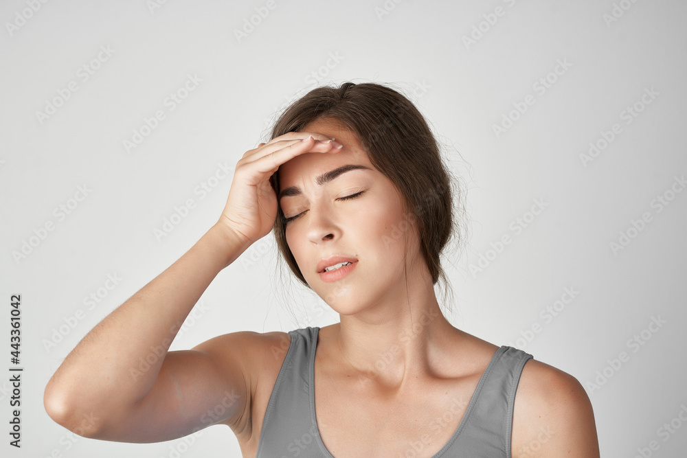 woman in gray t-shirt holding her head depression migraine stress woman in gray t-shirt holding her head depression migraine stress