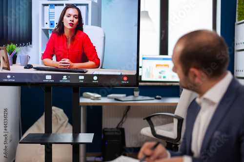 Executive manager discussing with remote colleagues on video call sitting in business office Business people talking to webcam, do online conference participate internet brainstorming, distance office