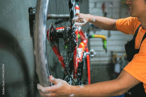 Bicycle mechanic. He is cleaning, washing bikes. Road bikes.