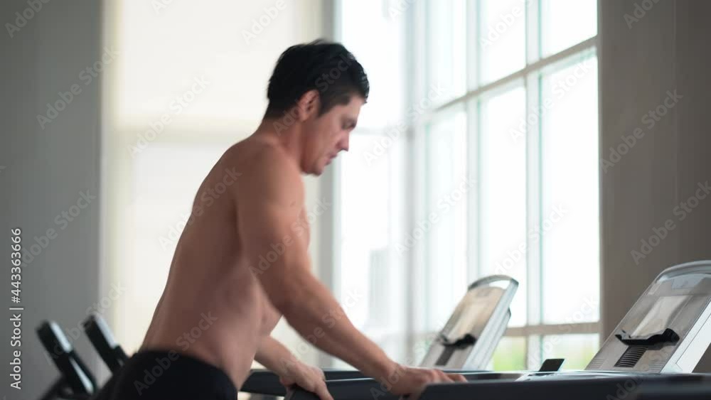 Handsome muscular man running on treadmill in fitness gym at sport club . motivation and workout . Shirtless sport guy Exercise on running Machine. bodybuilder cardio training Handsome muscular man running on treadmill in fitness gym at sport club . motivation and workout . Shirtless sport guy Exercise on running Machine. bodybuilder cardio training