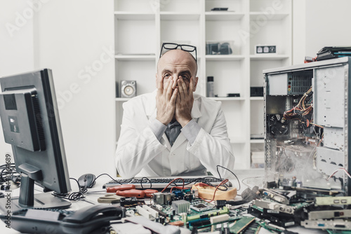 Obraz na plátně Frustrated exhausted technician repairing a computer