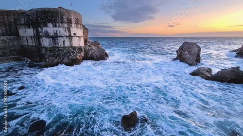Rough sea with waves and rocks at sunset in dubrovnik