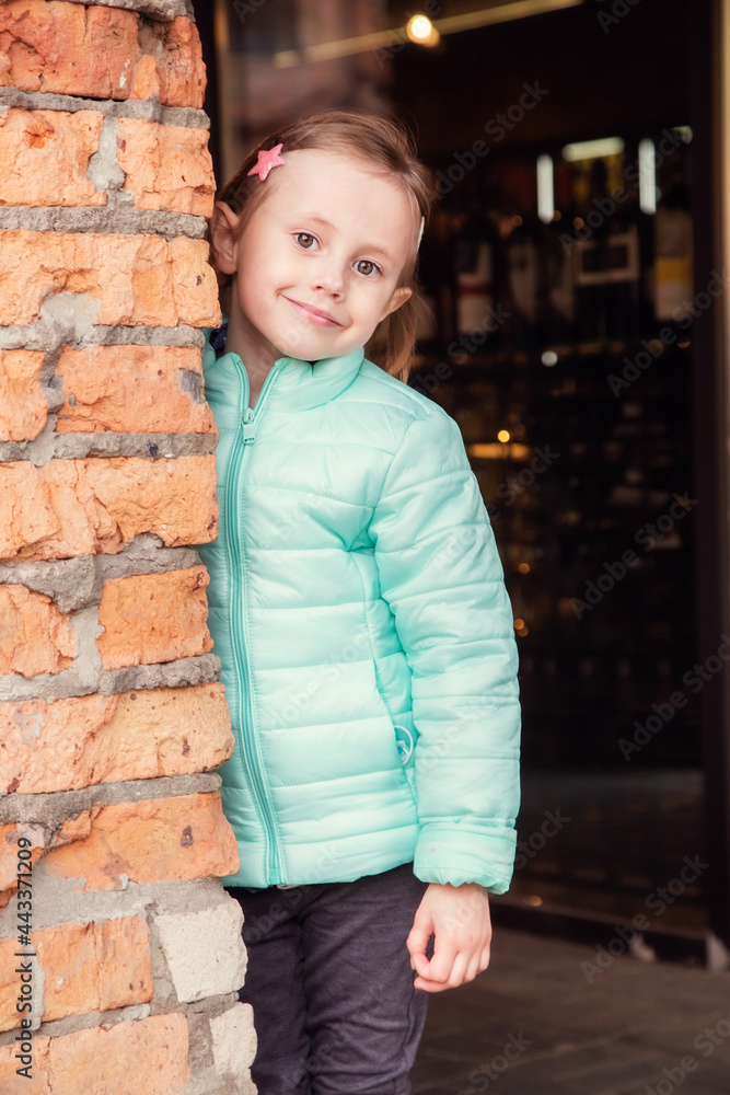 Portrait of a little caucasian blonde girl near a brick wall Portrait of a little caucasian blonde girl near a brick wall