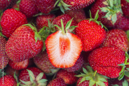 Fresh strawberries, a strawberry berry is cut in half and a red juicy core is visible