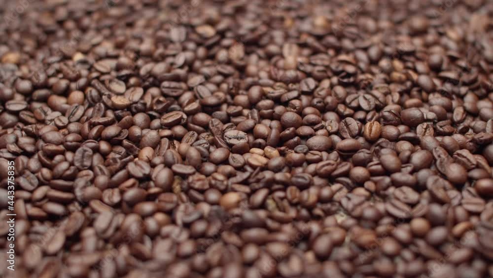 Coffee beans fill the entire space. Many roasted coffee beans lie in a heap as a background. Coffee beans fill the entire space. Many roasted coffee beans lie in a heap as a background.