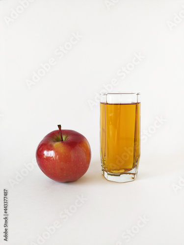 Red apple and glass of apple juice on white background