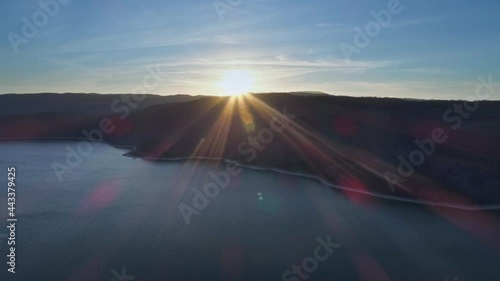 Cinematic aerial shot showing beautiful sunset behind mountain range at Lac de Vouglans in Haut-Jura department,France photo