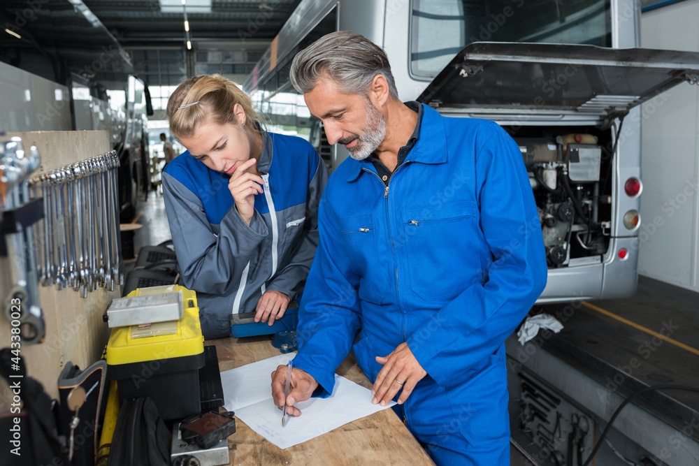 two workers in a garage two workers in a garage