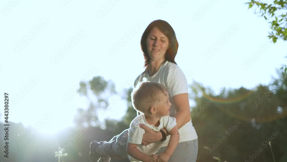 Happy family. Mom play with baby in park. Mom throws baby in her arms