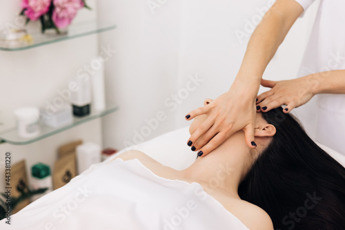 Caucasian woman receiving a facial massage at an aesthetic salon. Face Massage in beauty spa salon. Spa facial Massage. Body care, skin care, wellness, wellbeing, beauty treatment concept