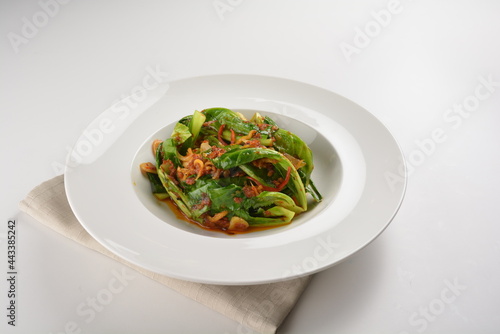 stir fried kai lan vegetable with spicy chilli sambal sauce in white plate asian halal menu