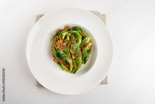 stir fried kai lan vegetable with spicy chilli sambal sauce in white plate asian halal menu