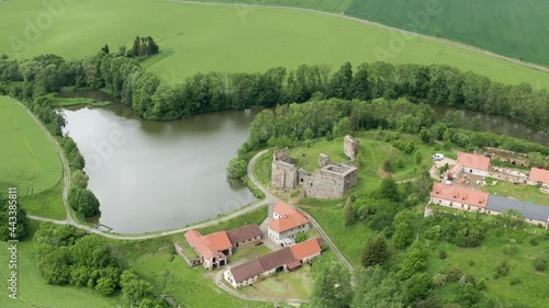 A picturesque scenery opens up from the air on the ruins of Borotin castle A stone fortress stands on the bank of the Dyje river, surrounded by lush trees, green grass The rural road is curling nearby photo