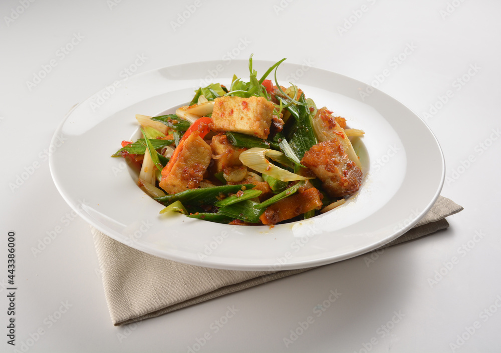 stir fried vegetable with bean curd tofu in spicy sambal chilli sauce in white plate asian halal menu