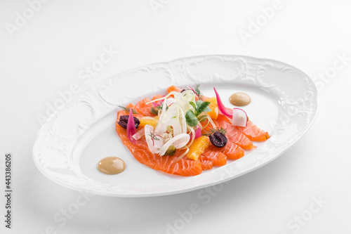 Slices of homemade smoked salmon fillet with olives and onion isolated on white background