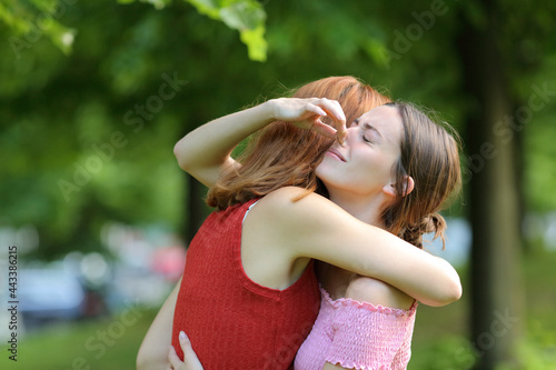 Woman embracing friend holding her nose to avoid bad smell