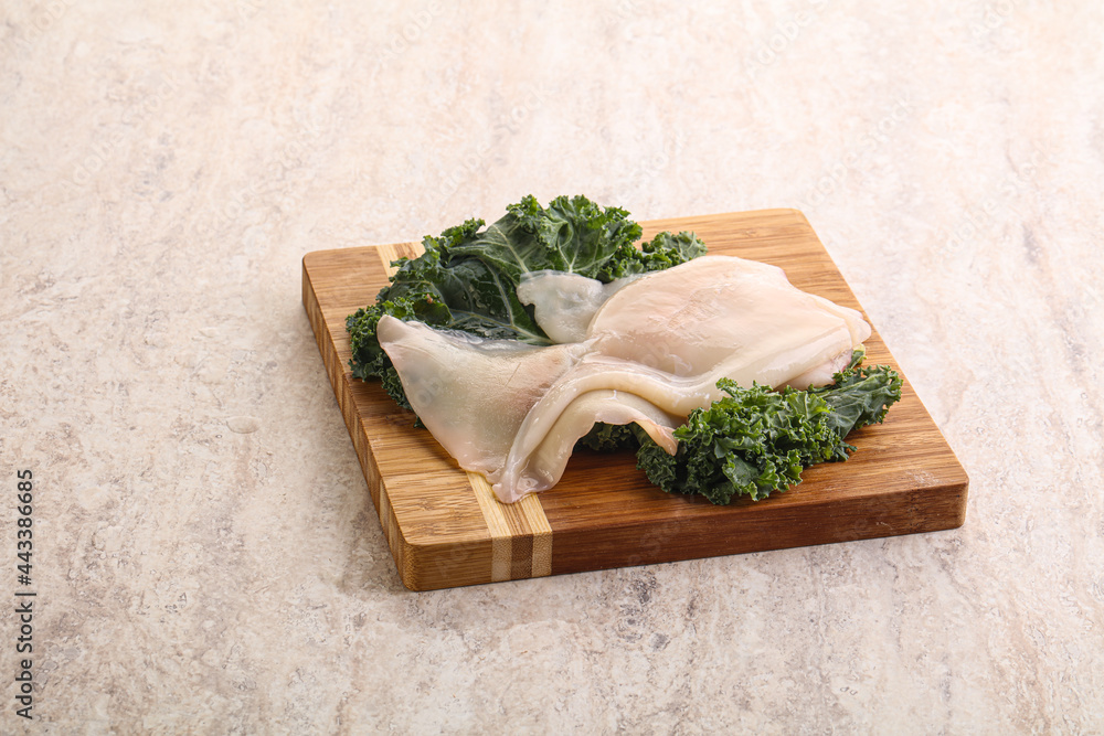 Raw squid over wooden board