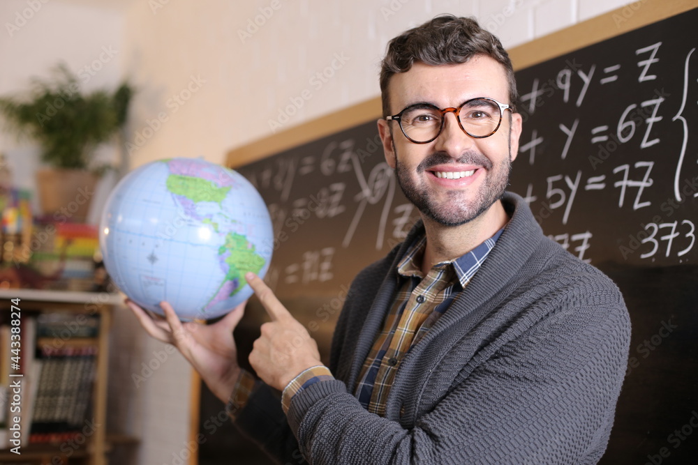 Geography teacher showing the globe in classroom Geography teacher showing the globe in classroom