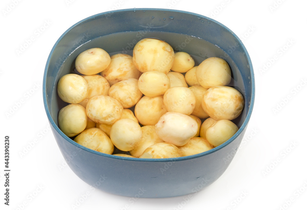 Raw peeled yellow young potatoes in water in the bowl Raw peeled yellow young potatoes in water in the bowl