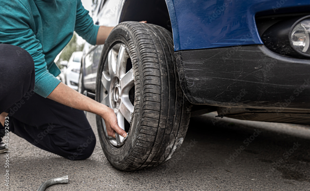 Close-up a man changes a wheel in a car on the road. Close-up a man changes a wheel in a car on the road.