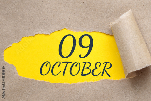 october 09. 09th day of the month, calendar date.Hole in paper with edges torn off. Yellow background is visible through ragged hole.Autumn month, day of the year concept photo