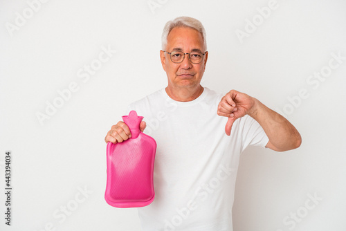 Senior american man holding a hot water bottle isolated on white background showing a dislike gesture, thumbs down. Disagreement concept.