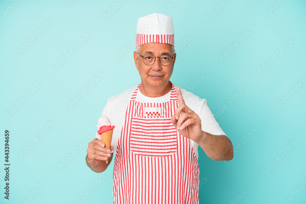 Senior american ice cream maker holding an ice cream isolated on blue background showing number one with finger. Senior american ice cream maker holding an ice cream isolated on blue background showing number one with finger.