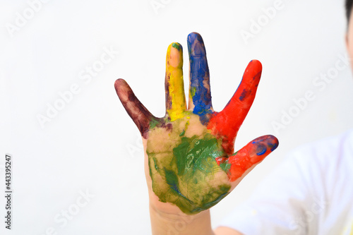 Colourful painted child hand up isolated on white background. Creative, funny, artistic and happy