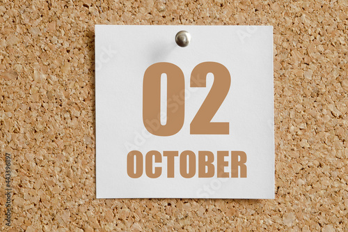 october 02. 02th day of the month, calendar date.White calendar sheet attached to brown cork board.Autumn month, day of the year concept photo