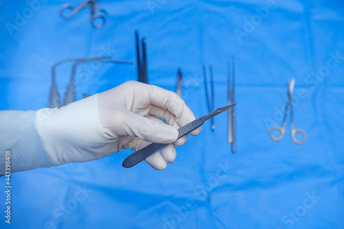 Surgeon holds scalpel in operating theatre