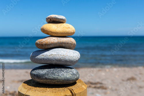 Stones of different colors and sizes placed one on top of the other in perfect balance in front of the sea.