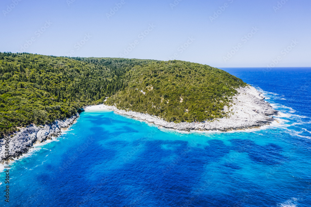 Aerial view of remote Dafnoudi beach in Kefalonia, Greece. Secluded bay with pure crystal clean turquoise sea water surrounded by cypress trees.