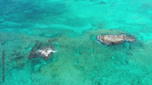 Aerial view of coral rocks surrounded by clear blue water off North Bimini, Bahamas in summer 4K. photo