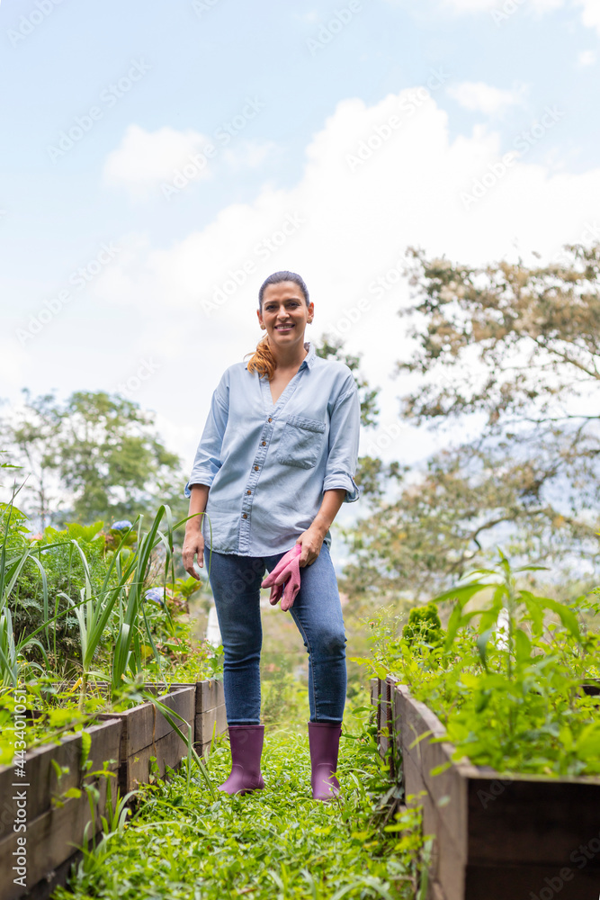 Fototapeta premium vertical shot of a woman standing in her orchard