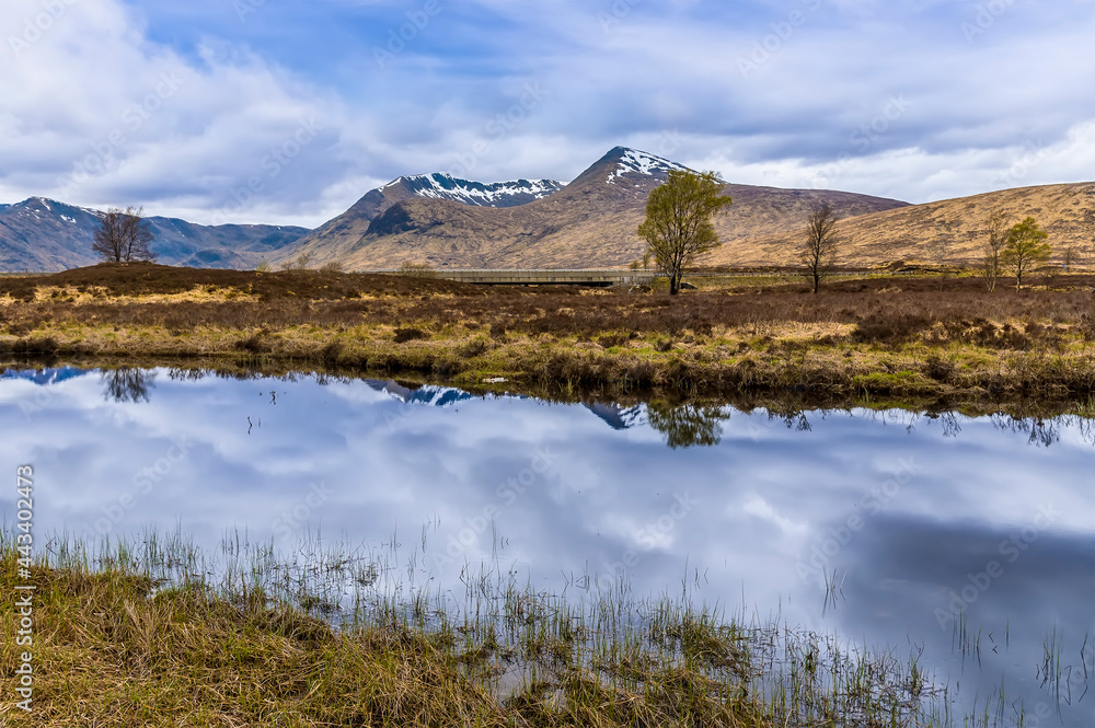 A view across Rannoch Moor and in the shallow waters of Loch Ba near Glencoe, Scotland on a summers day