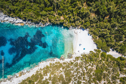 Aerial top down view of remote Dafnoudi beach in Kefalonia, Greece. Secluded bay with pure crystal clean turquoise sea water surrounded by cypress trees.