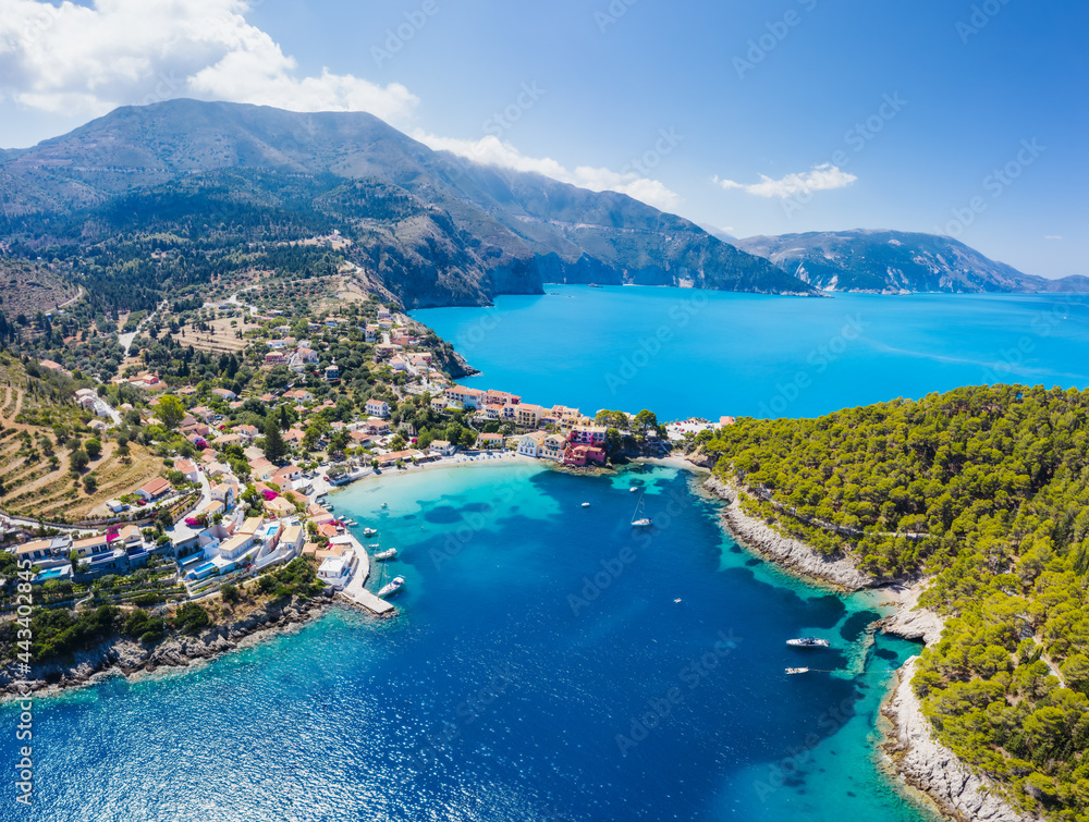 Panoramic aerial view to the picturesque fishing village of Assos, Kefalonia, Greece. Travel sailing boats moored over the turquoise sea
