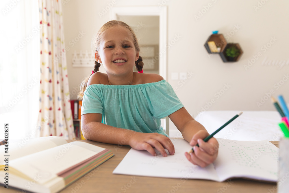 Happy caucasian girl having video call during class, sitting at desk at home Happy caucasian girl having video call during class, sitting at desk at home