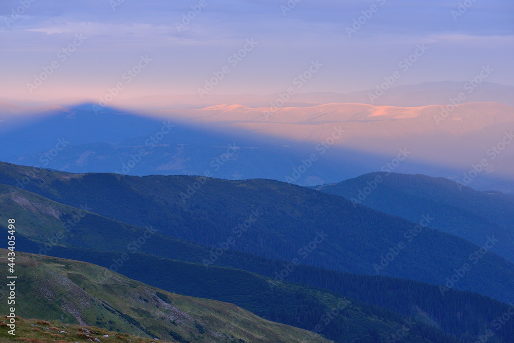 Summer landscape panorama, shadow of mountain at sunrise