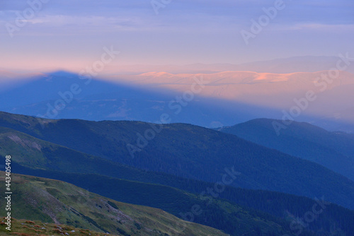 Summer landscape panorama, shadow of mountain at sunrise