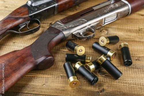 hunting rifles and cartridges are on wooden background, studio photo shot. hunter guns and bullets close up photo