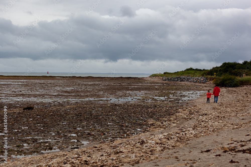 Une petite fille et sa grand-mère se promènent à la plage à marée basse à Penvins Bretagne France