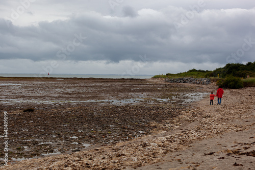 Une petite fille et sa grand-mère se promènent à la plage à marée basse à Penvins Bretagne France photo