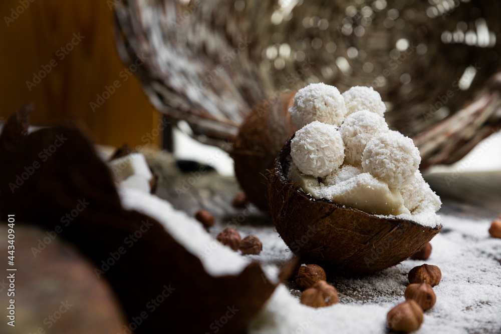 Coconut candy, balls, coconuts and hazelnuts on a rustic wooden surface Coconut candy, balls, coconuts and hazelnuts on a rustic wooden surface