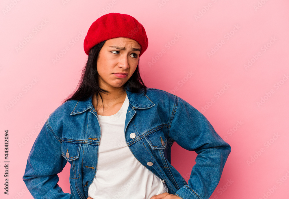 Young Venezuelan woman isolated on pink background confused, feels doubtful and unsure. Young Venezuelan woman isolated on pink background confused, feels doubtful and unsure.